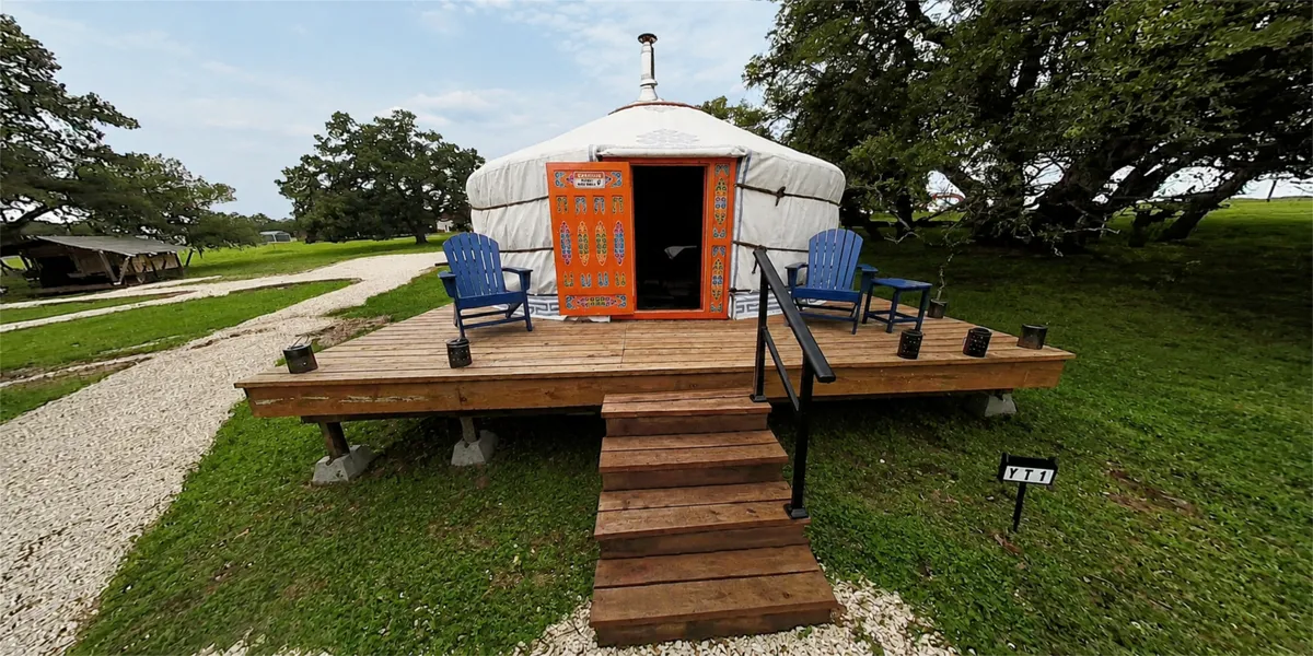 The Mongolian yurt with its orange door and deck chairs